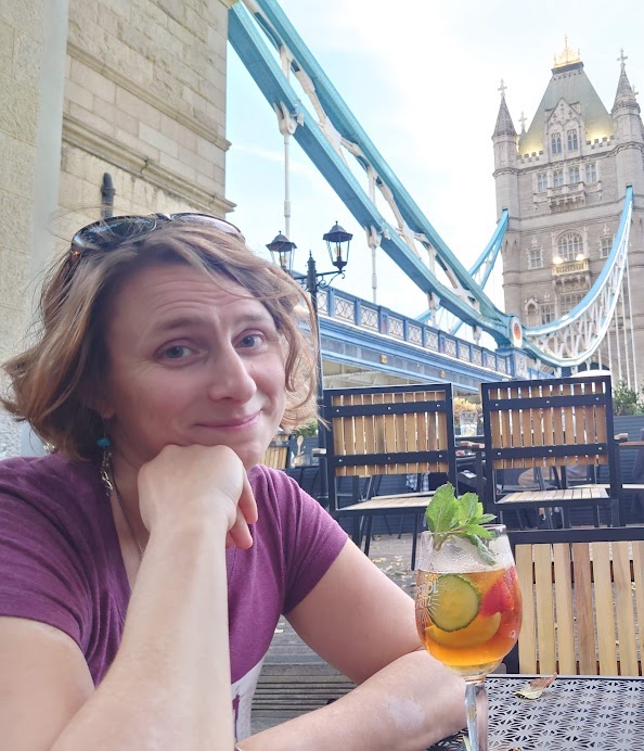 Picture of Marie Léger-St-Jean smiling next to a Pimm's cup, with Tower Bridge in the background, taken by Leon van Wissen in London on 29 October 2022